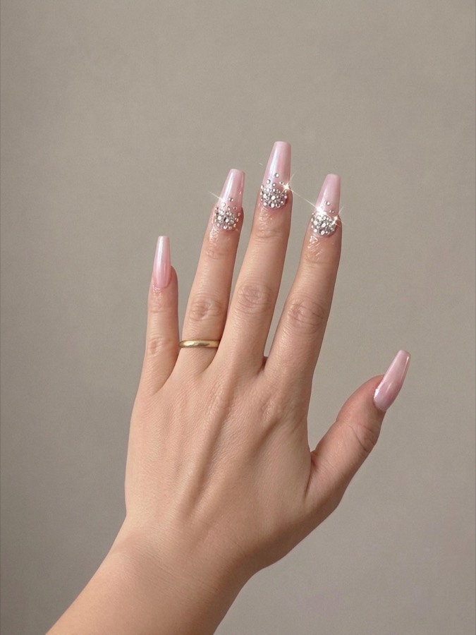 A hand wearing long pink nails produced in the app