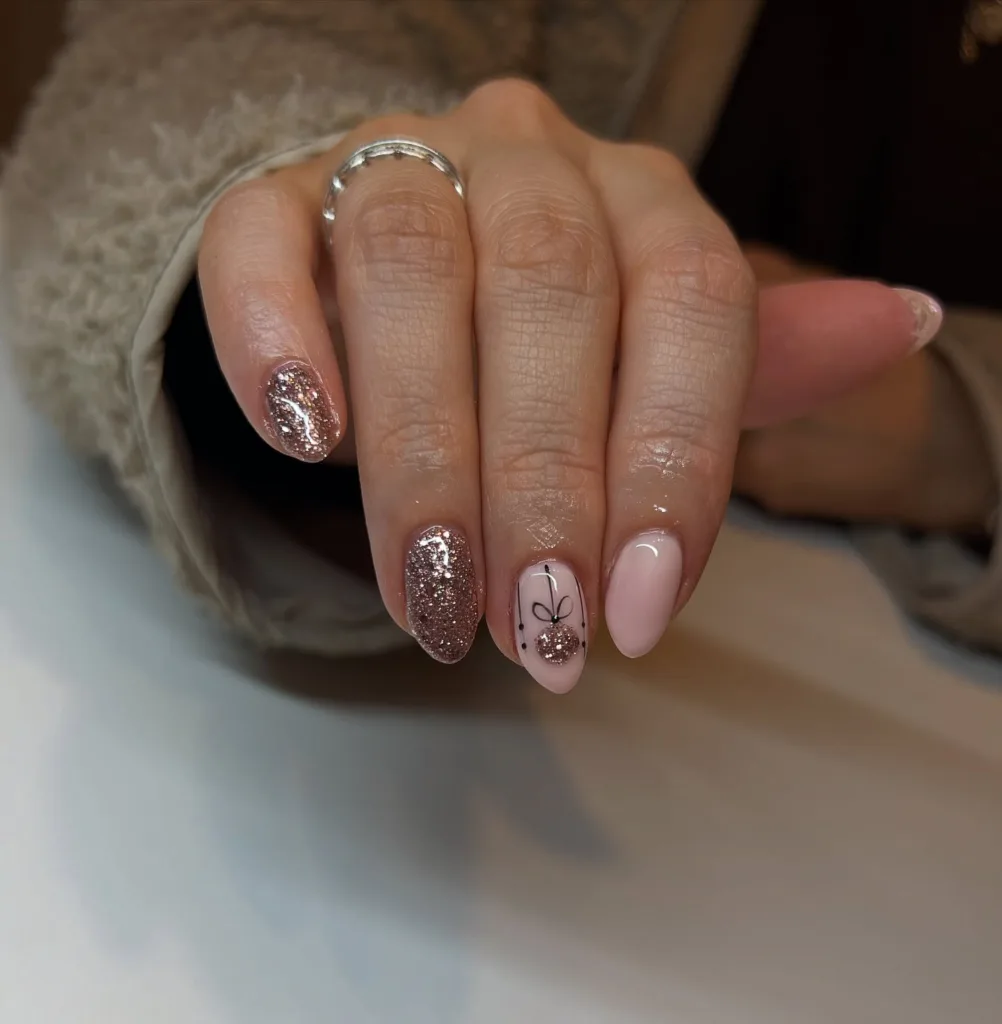 rose gold christmas nails with glitter and cute ornament accent