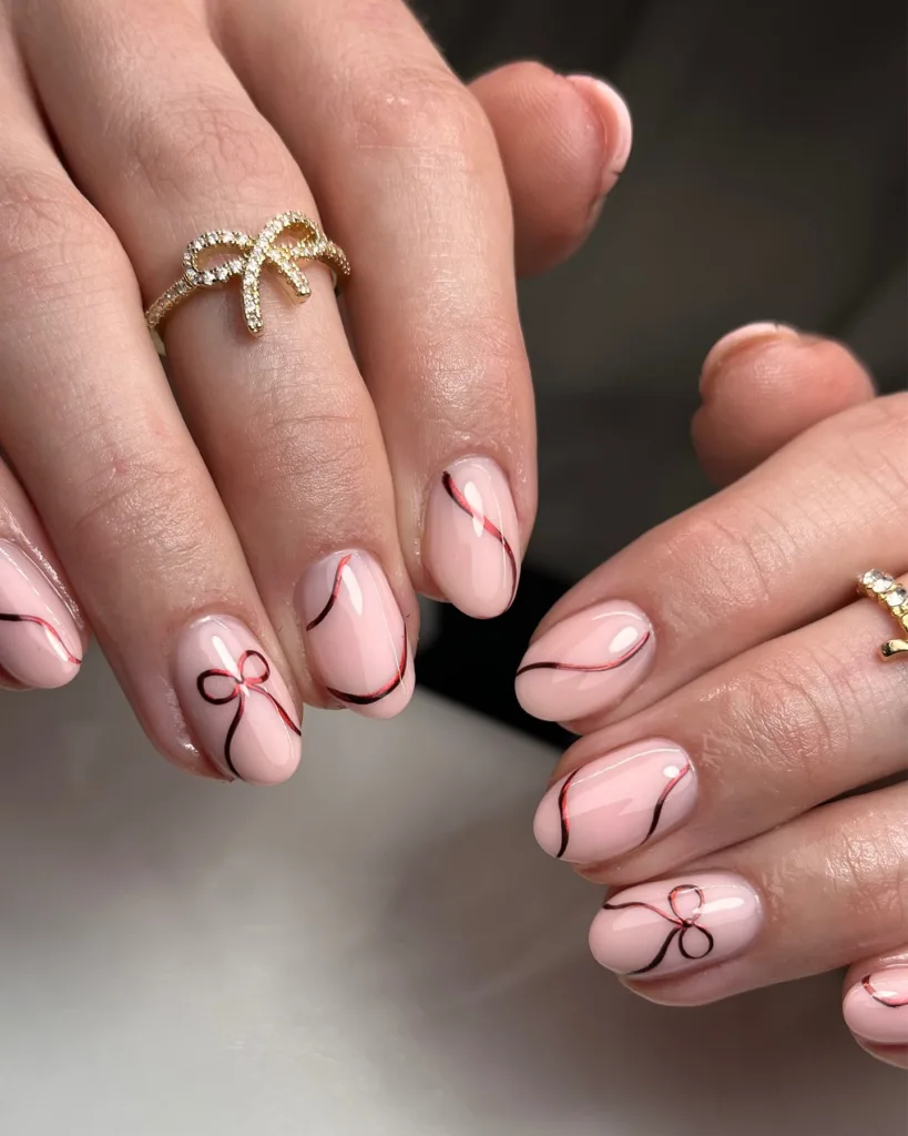 elegant christmas ribbon nails with thin red lines and tiny bow accents
