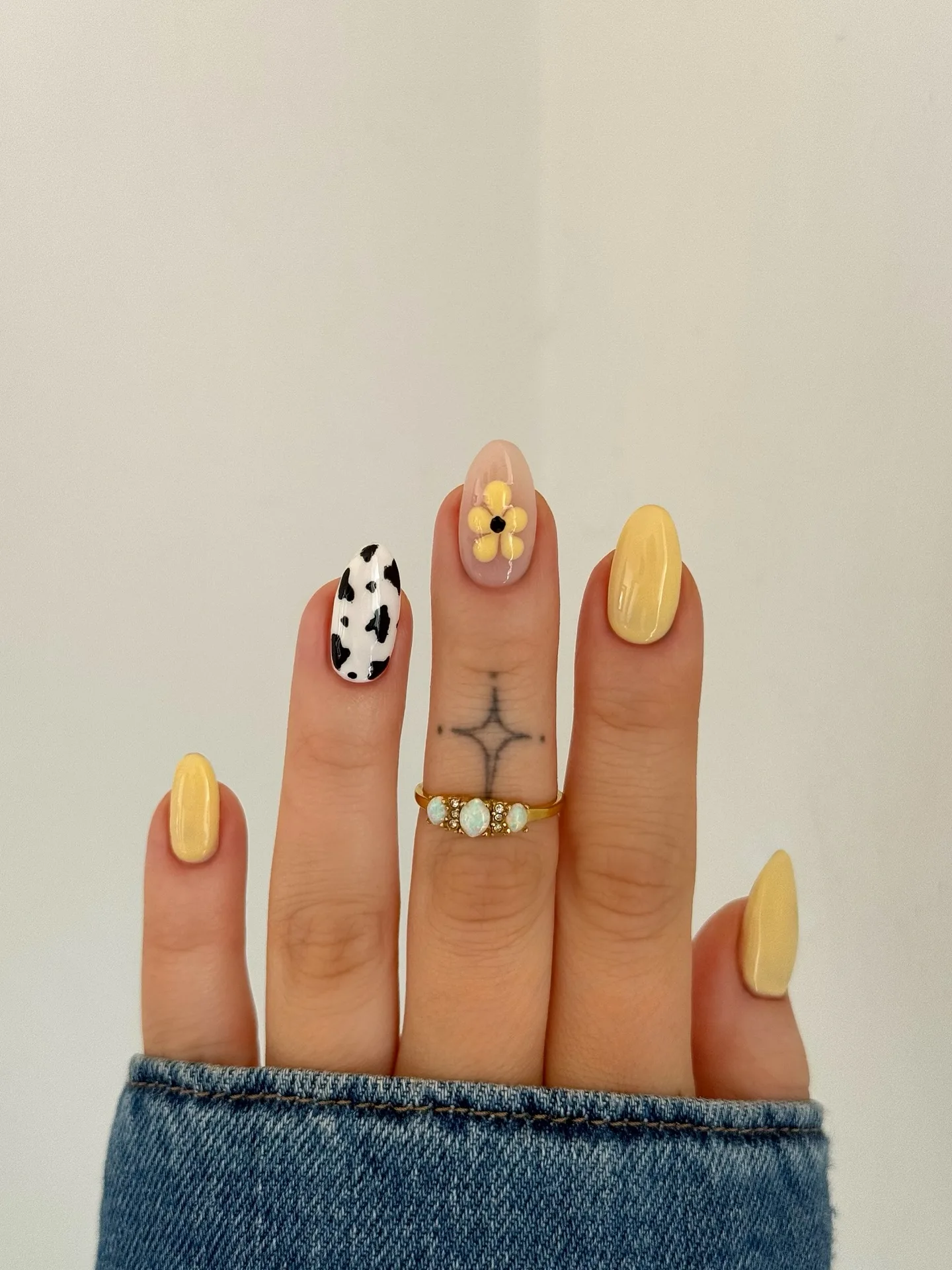 yellow almond daisy cow print nails