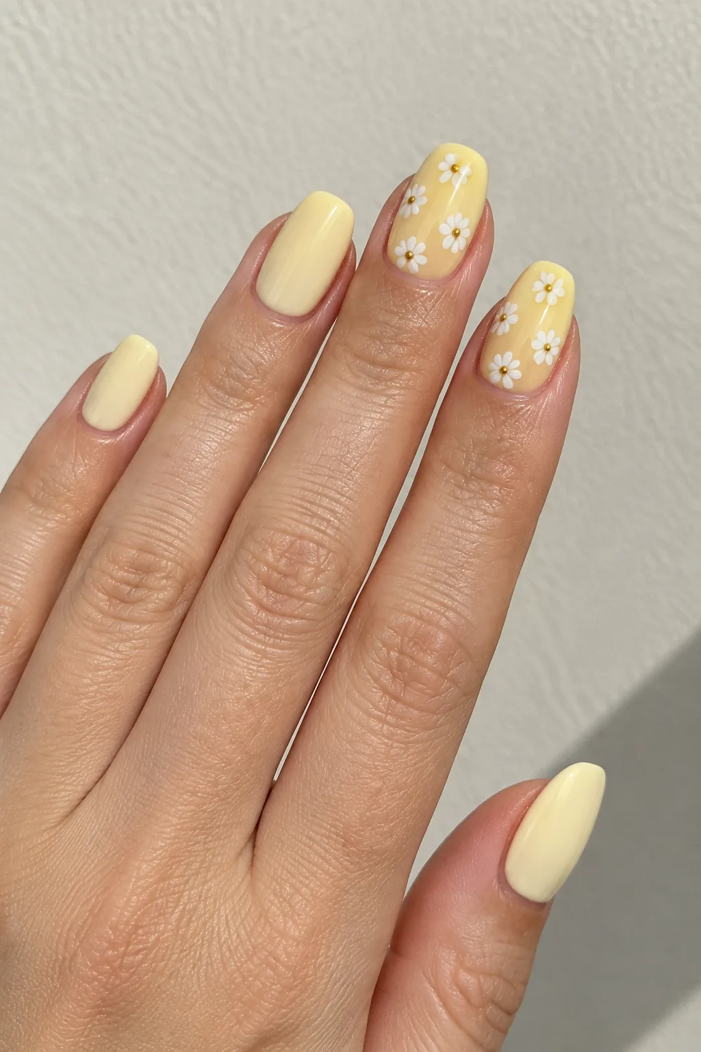 Butter yellow squoval nails with daisies comparing best nail shape for short fingers