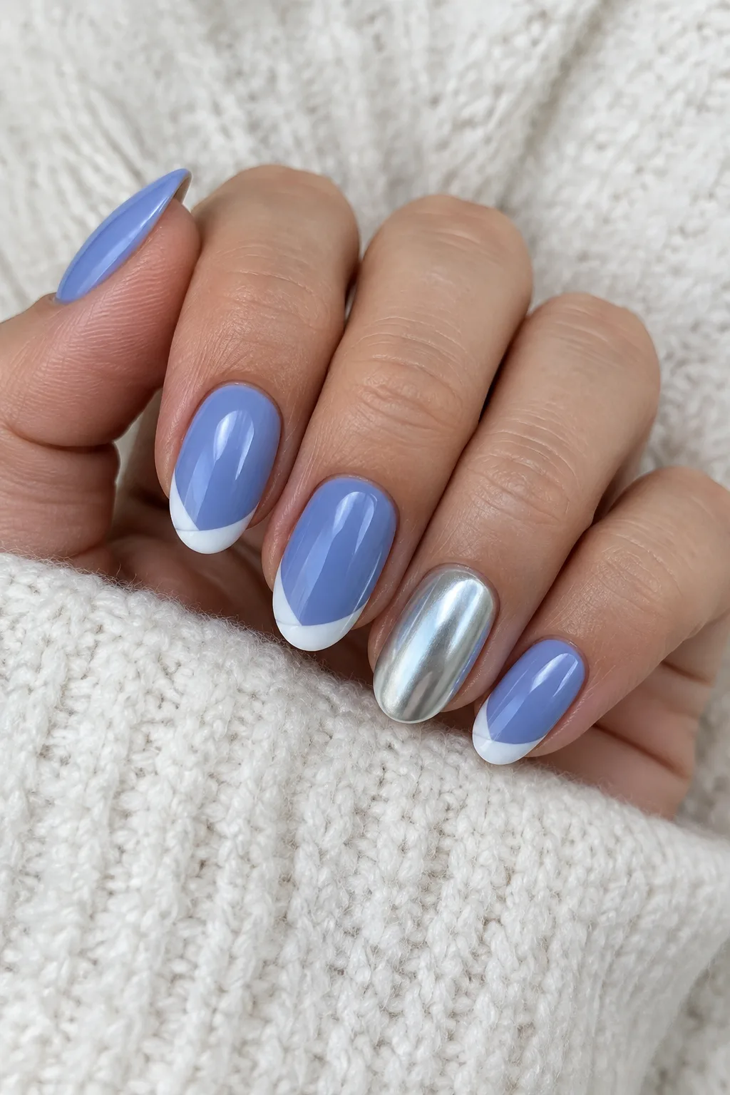 Short oval nails in periwinkle blue with diagonal white tips for a lengthening effect