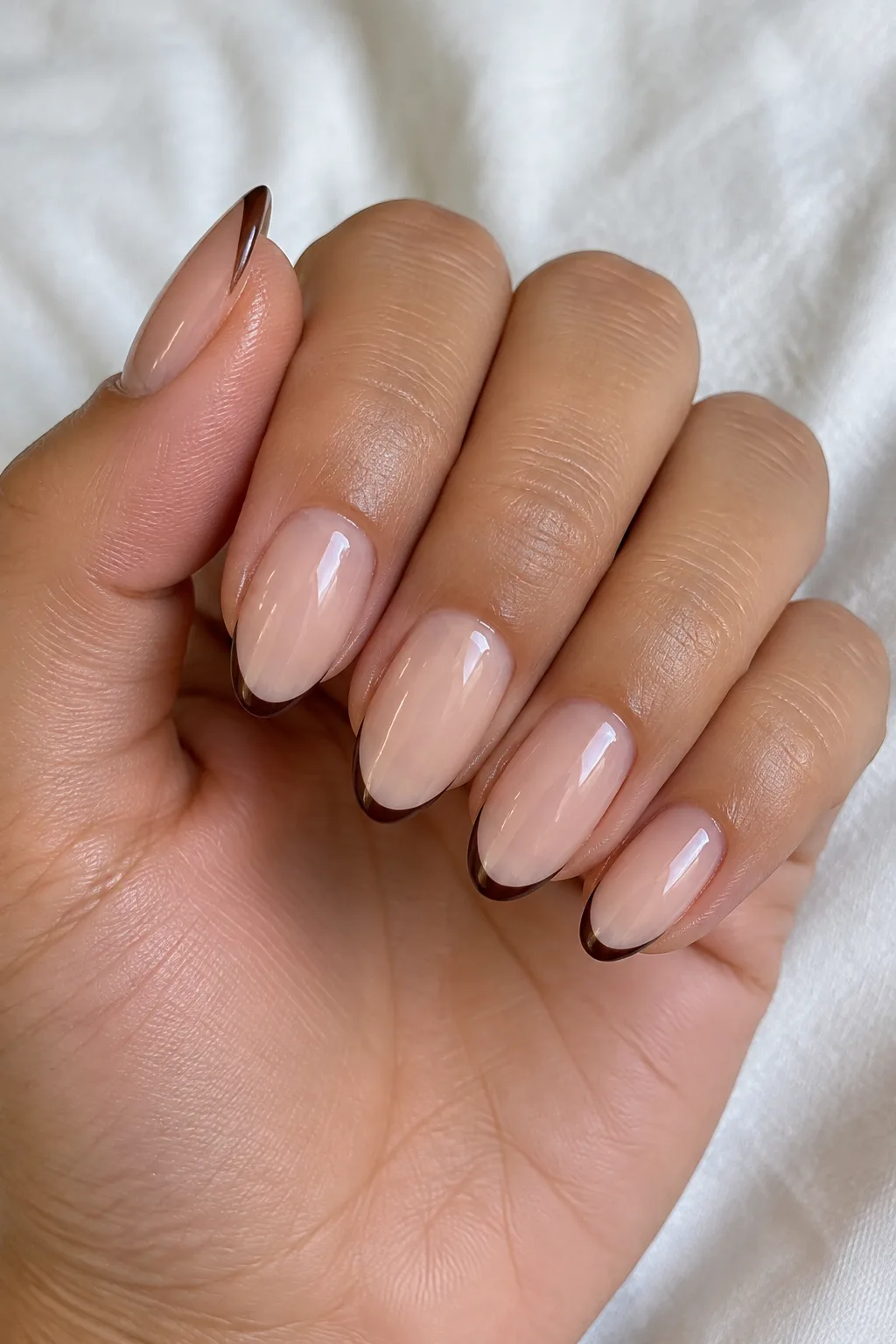 Almond nails with a skinny micro French tip in espresso brown