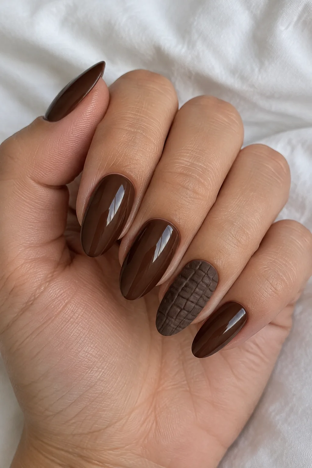 Chocolate brown almond nails with a textured croc-embossed accent nail