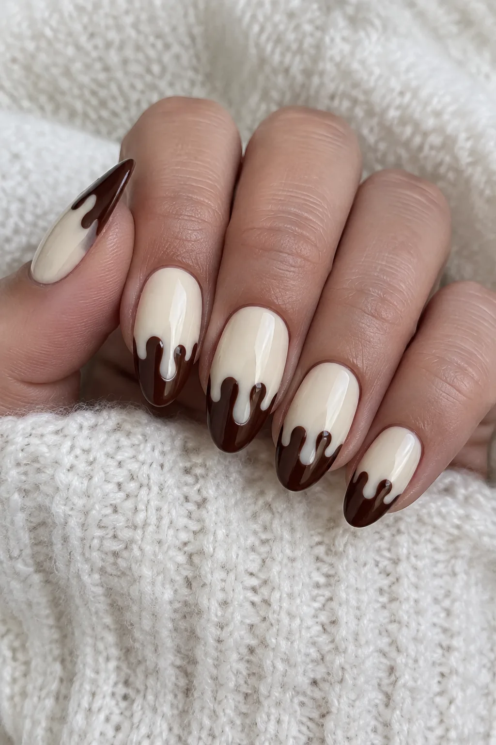 Cream and brown almond nails designed to look like dripping melted chocolate