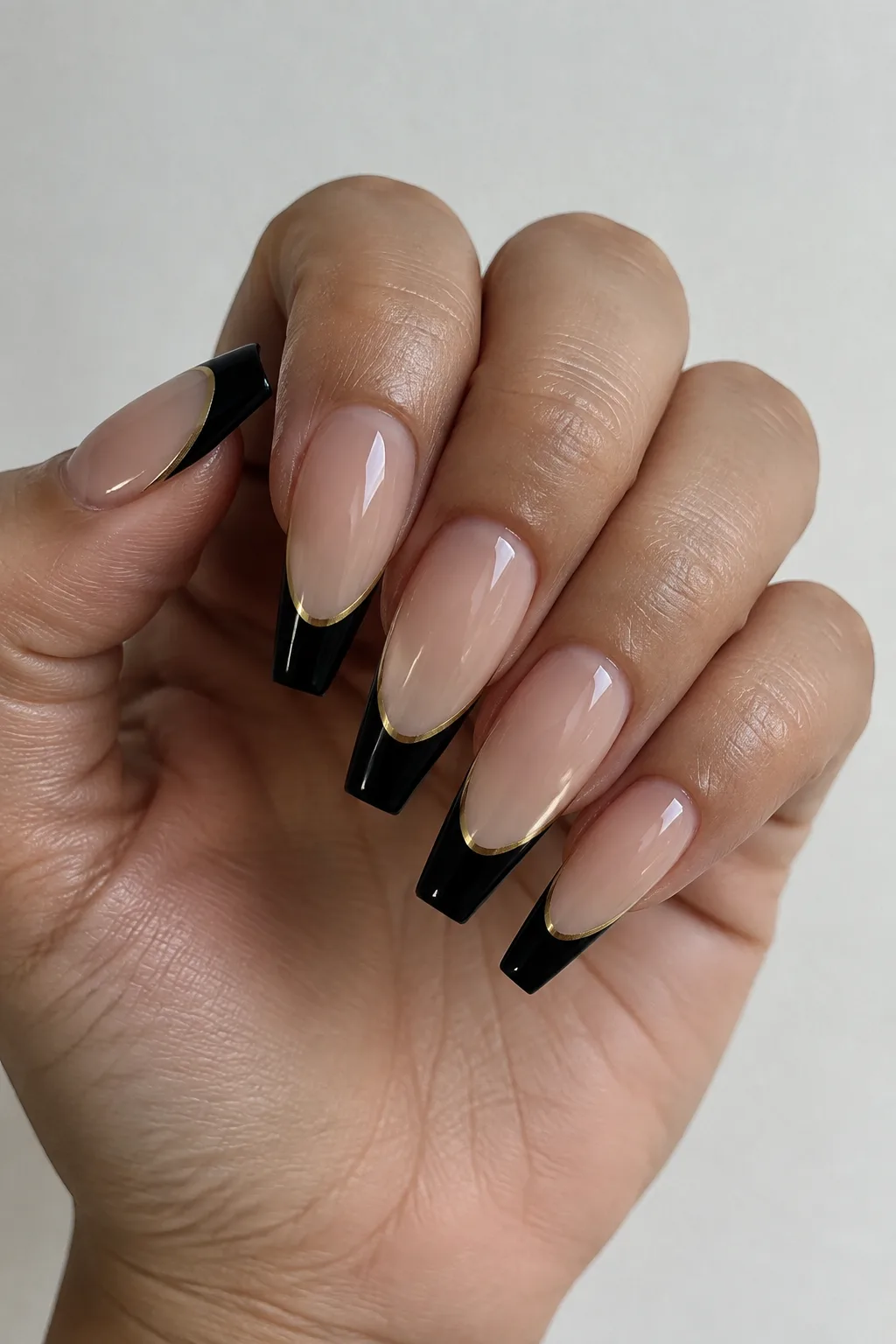 Black and gold double-lined French tips on long coffin nails