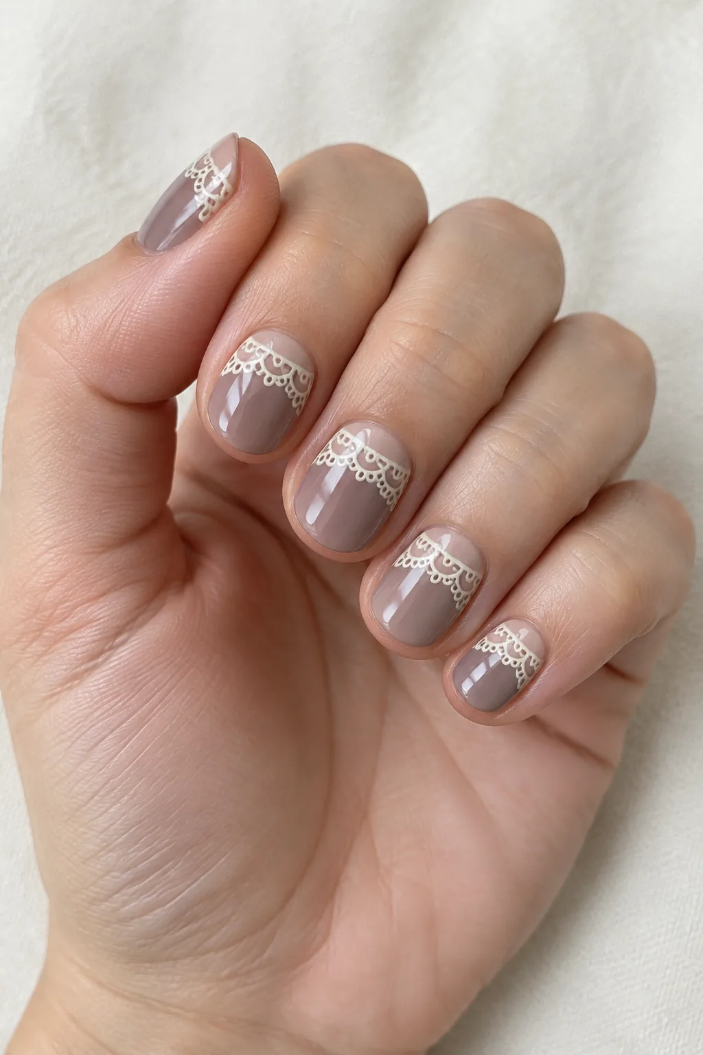 Dusty mauve polish with delicate white lace detailing near the tips