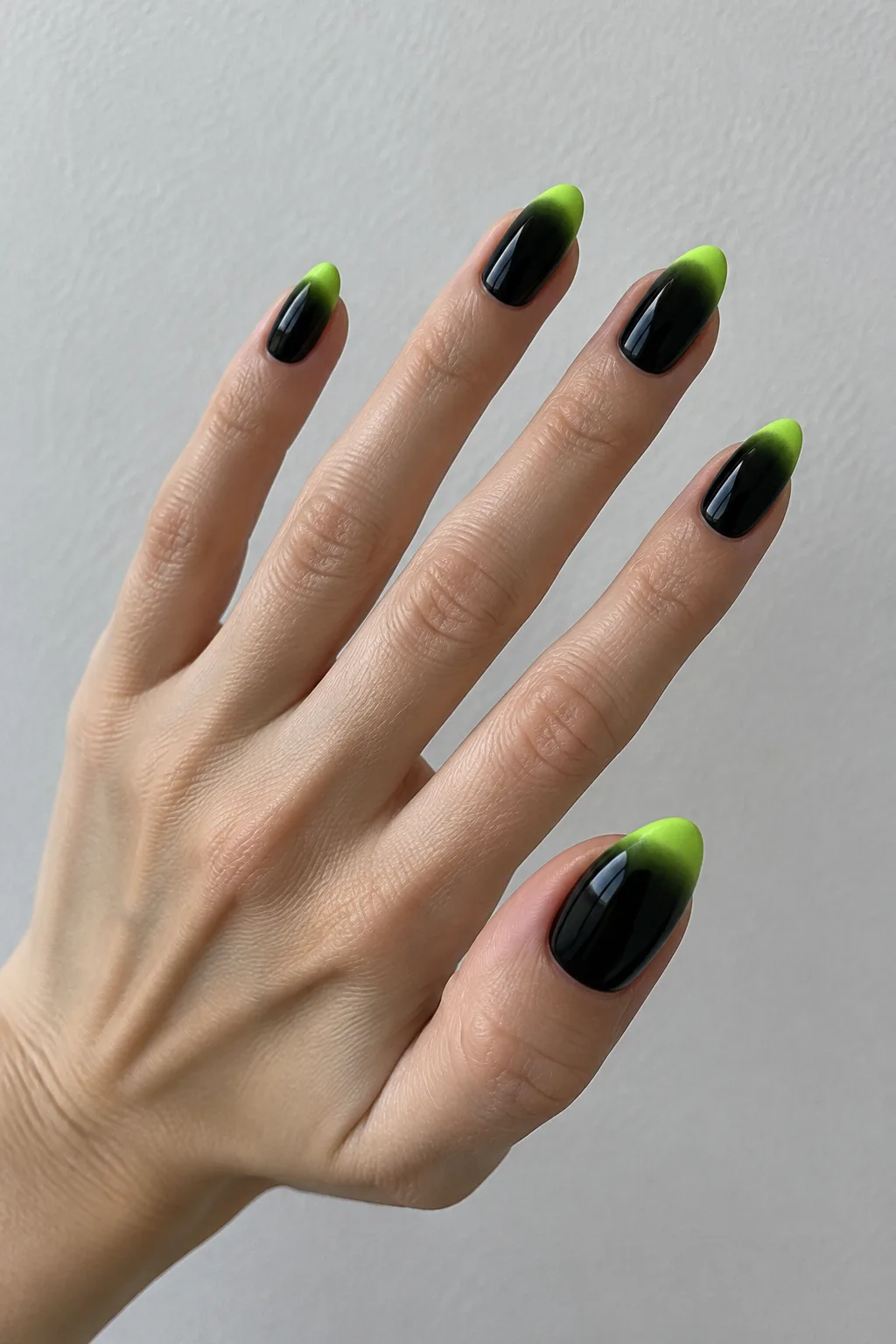 Black almond nails with a glowing acid green aura effect around the edges