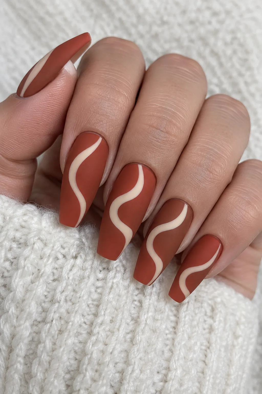Matte terracotta coffin gel nails with cream swirl art for a long-lasting manicure