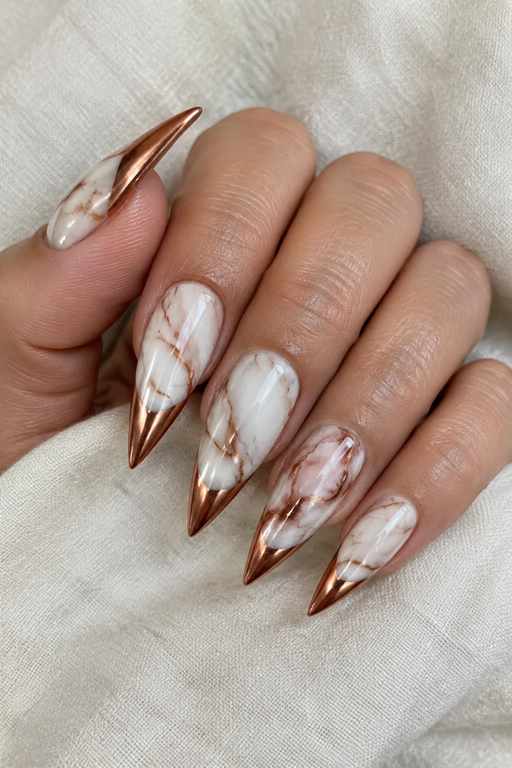 Long stiletto marble gel nails with copper chrome tips for a salon-quality set