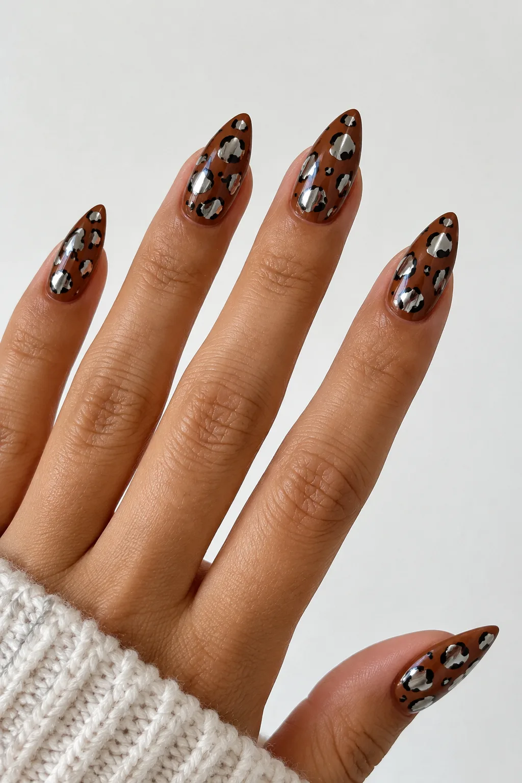 Chrome leopard print nails for autumn with silver spots on toffee base