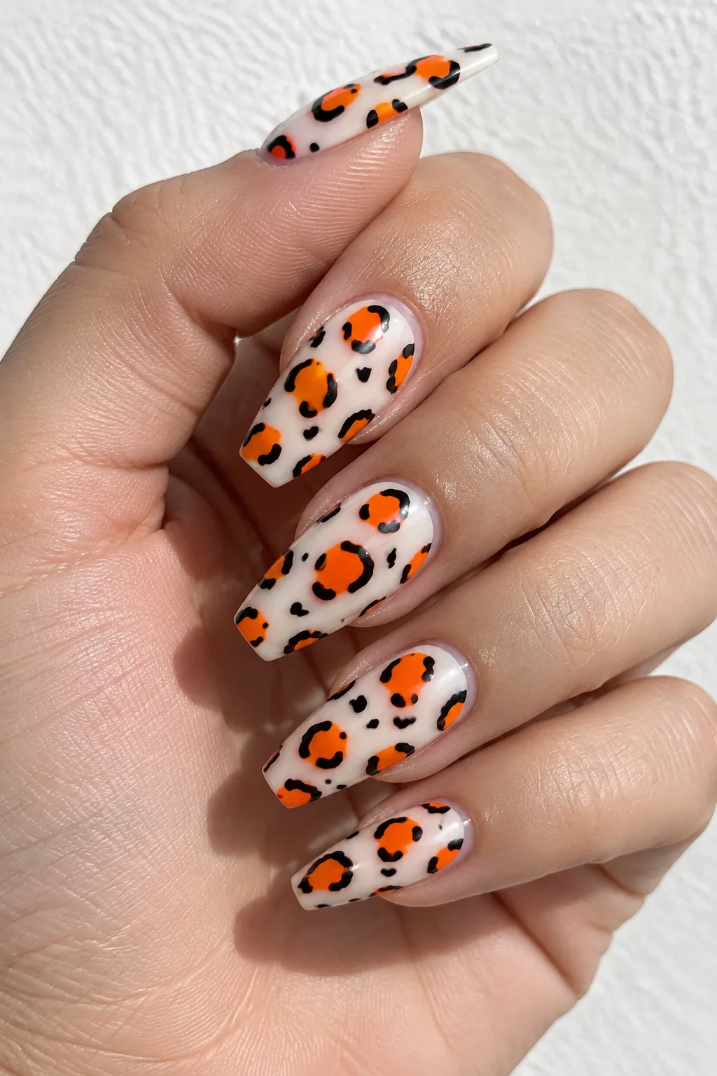 Neon orange leopard print nails for autumn on medium coffin nails