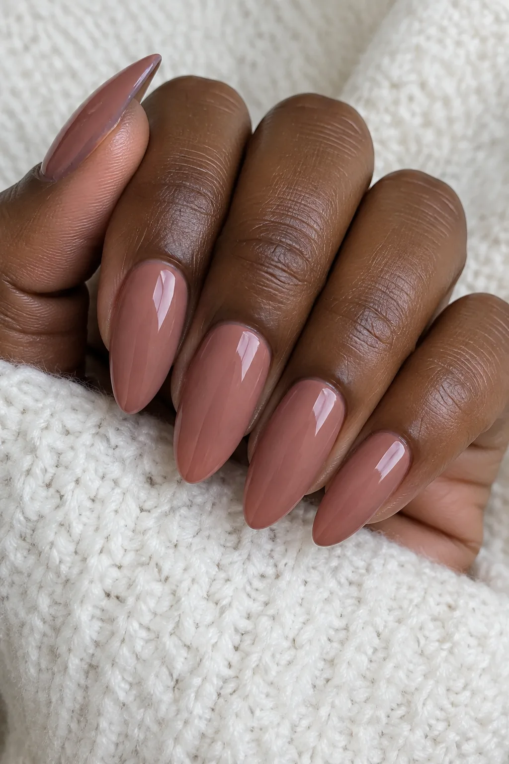 Rosewood brown polish on long almond-shaped nails with a glossy finish