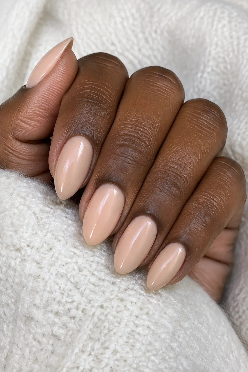 Peach praline polish on short almond nails with a soft satin finish