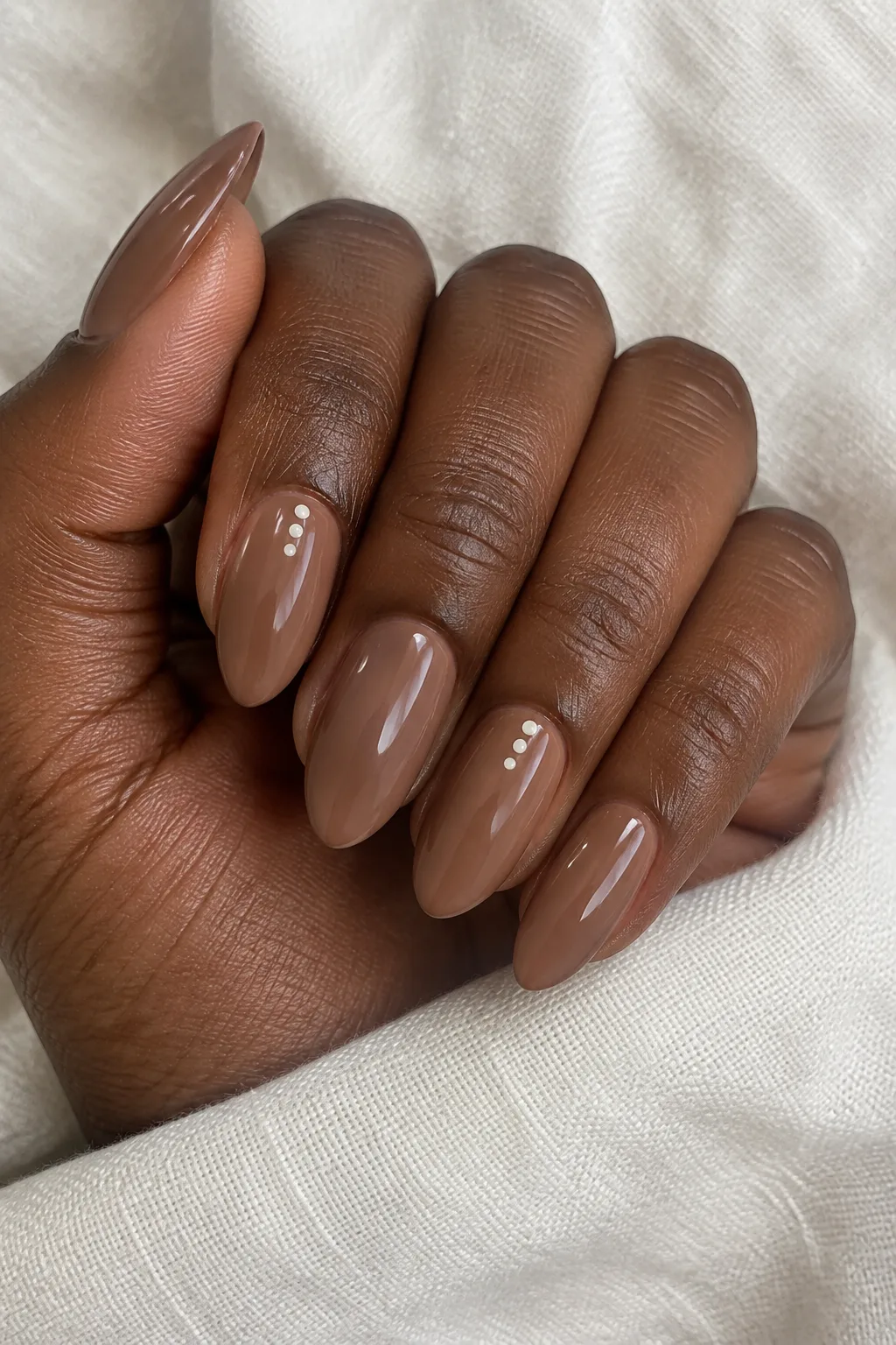 Nutmeg brown nails decorated with tiny cream cuticle dots