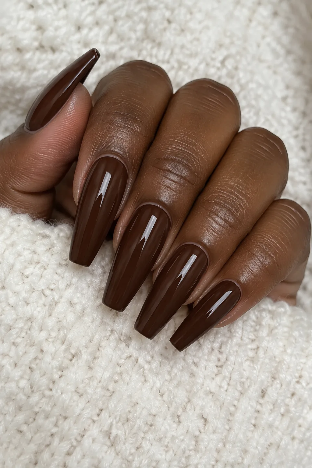 High-shine mocha brown polish on long coffin-shaped nails