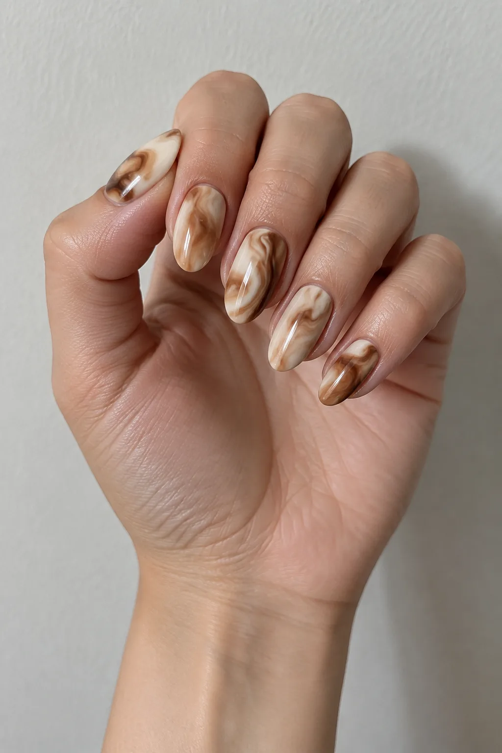 Medium oval nails with cocoa and cream latte-style marble swirls