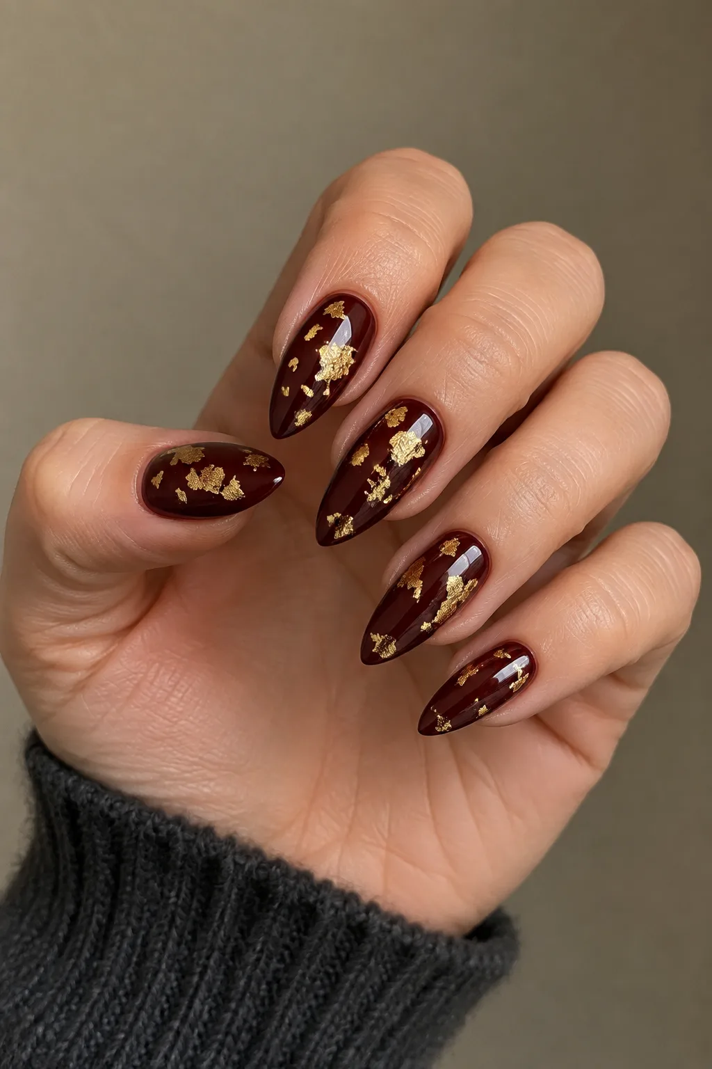 Oxblood with gold leaf flakes dark red fall nails on arrowhead shape