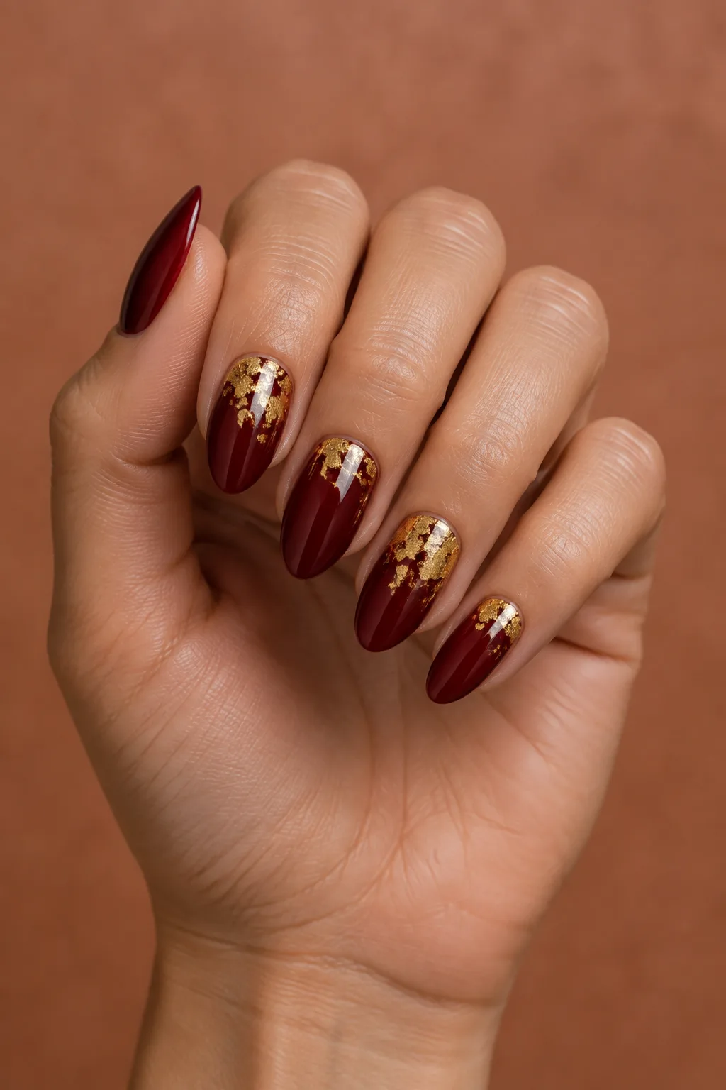 Medium lipstick shape hoco nails in deep red with gold foil flakes
