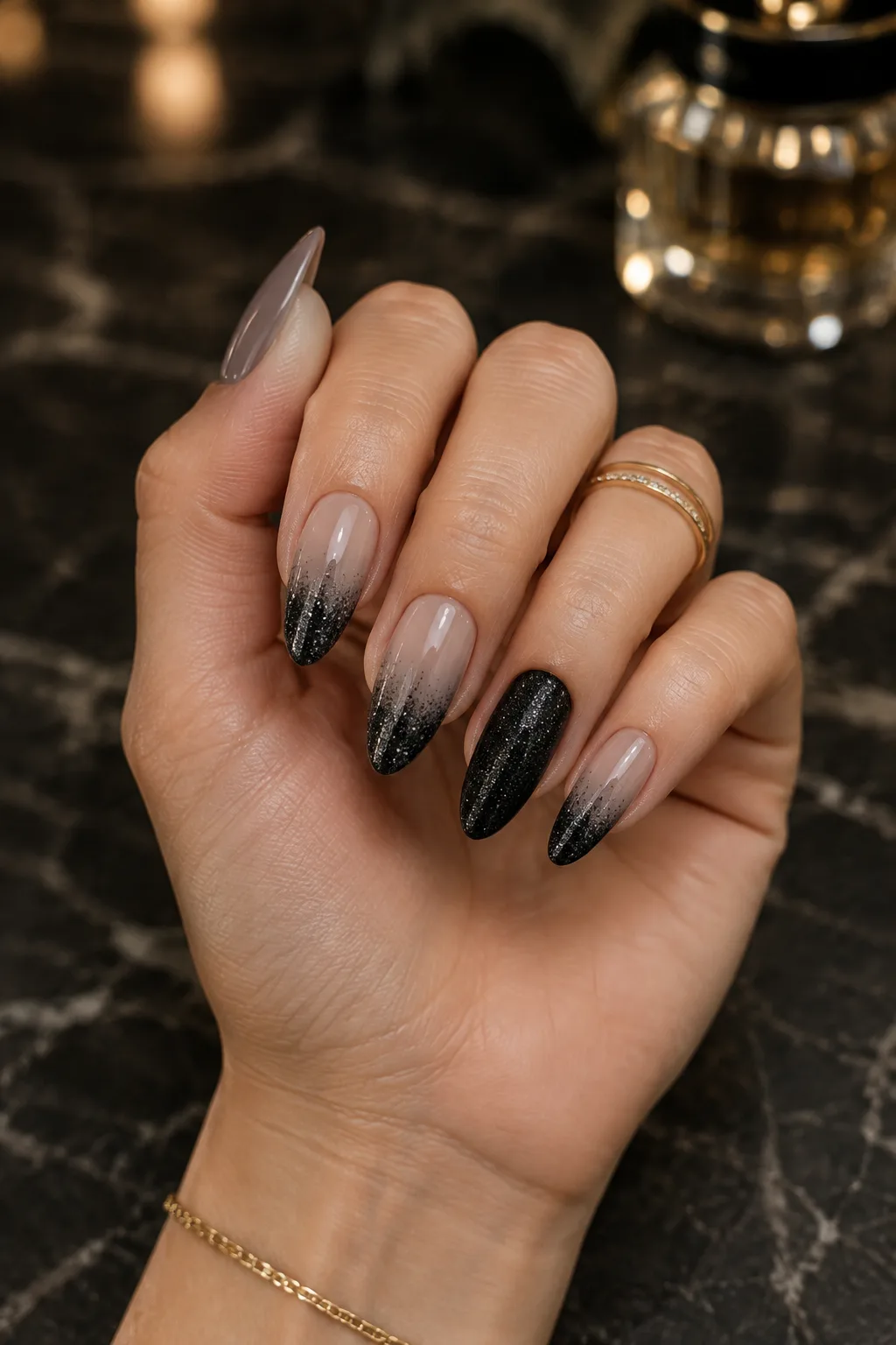 Matte black almond nails with a black glitter tip fade