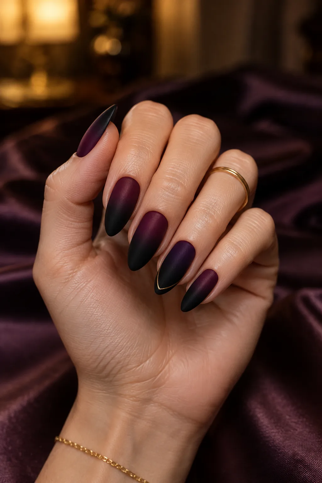 Matte black almond nails in a plum to black ombre