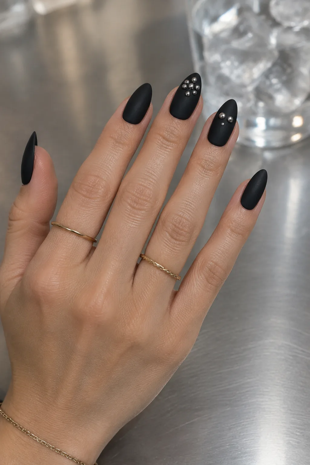 Matte black almond nails with raised silver chrome drops