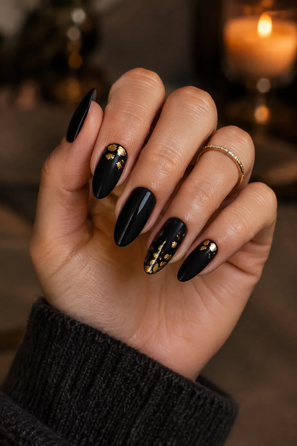 Matte black almond nails with gold leaf flecks