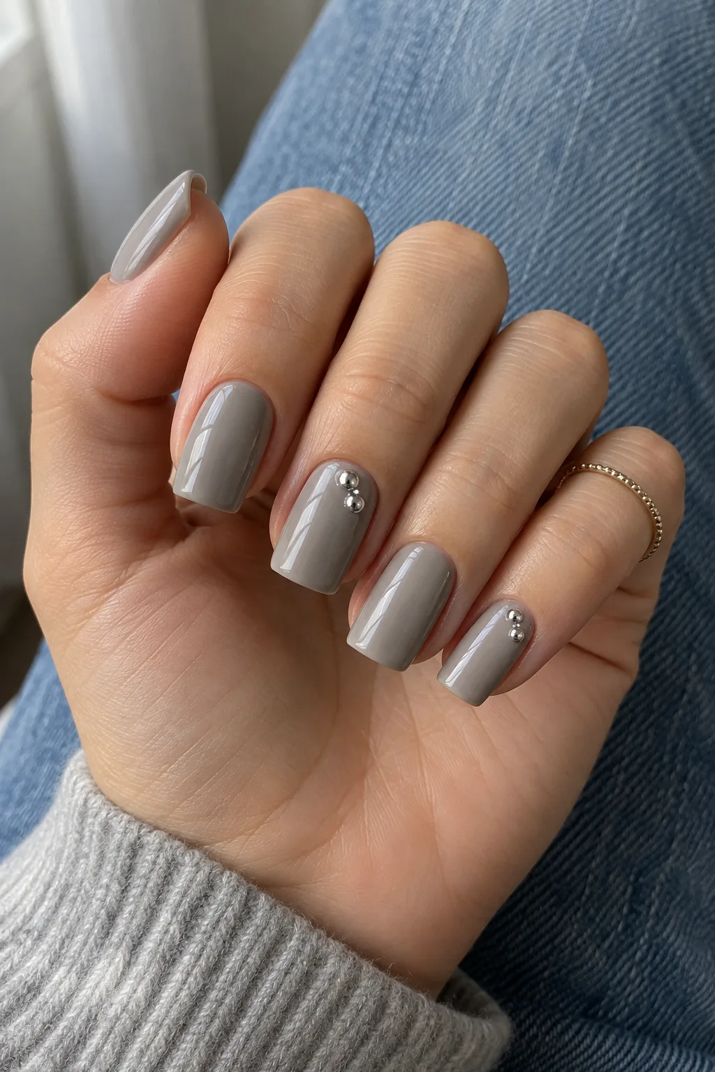 Minimalist winter nail designs with raised silver chrome drops on fog grey