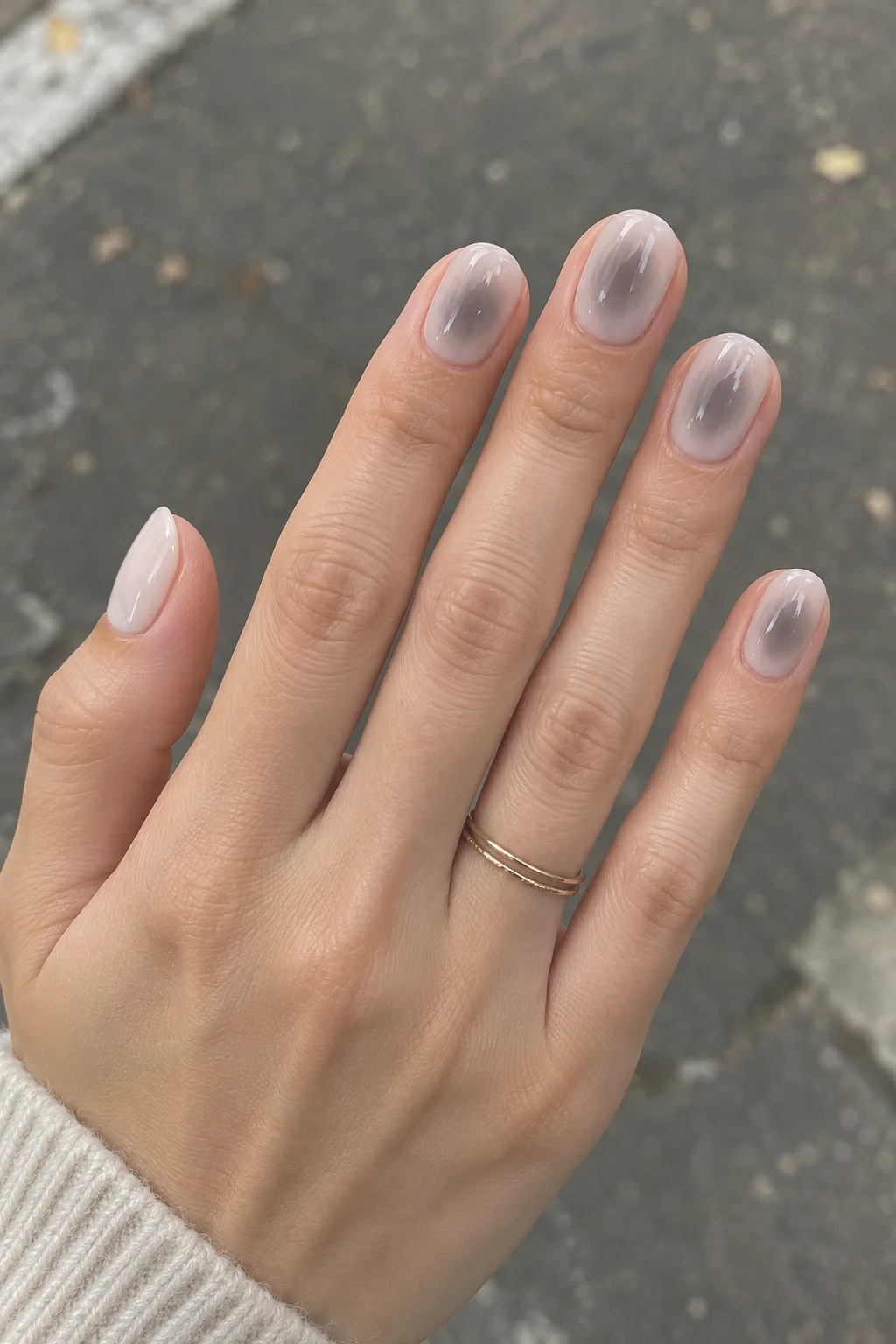 Minimalist winter nail designs with a soft grey aura glow on milky nails