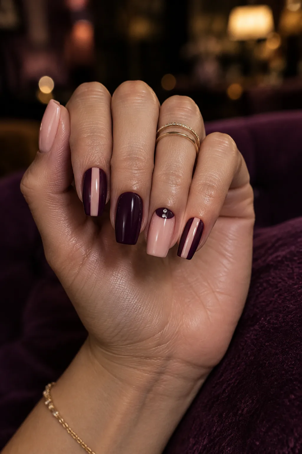 Deep plum negative space nails to wear with a gold party dress
