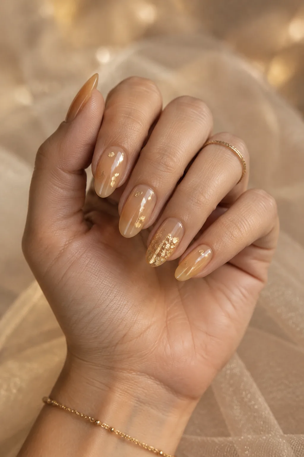 Honey jelly nails with gold flakes to wear with a gold party dress