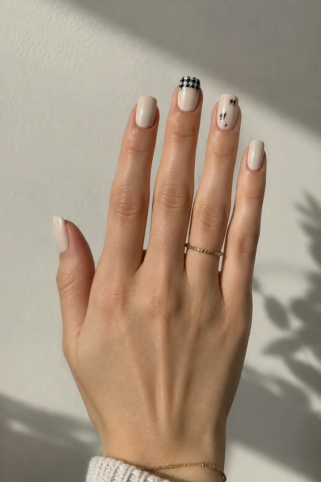 Cream square nails with black houndstooth tips, nails to wear with a red dress