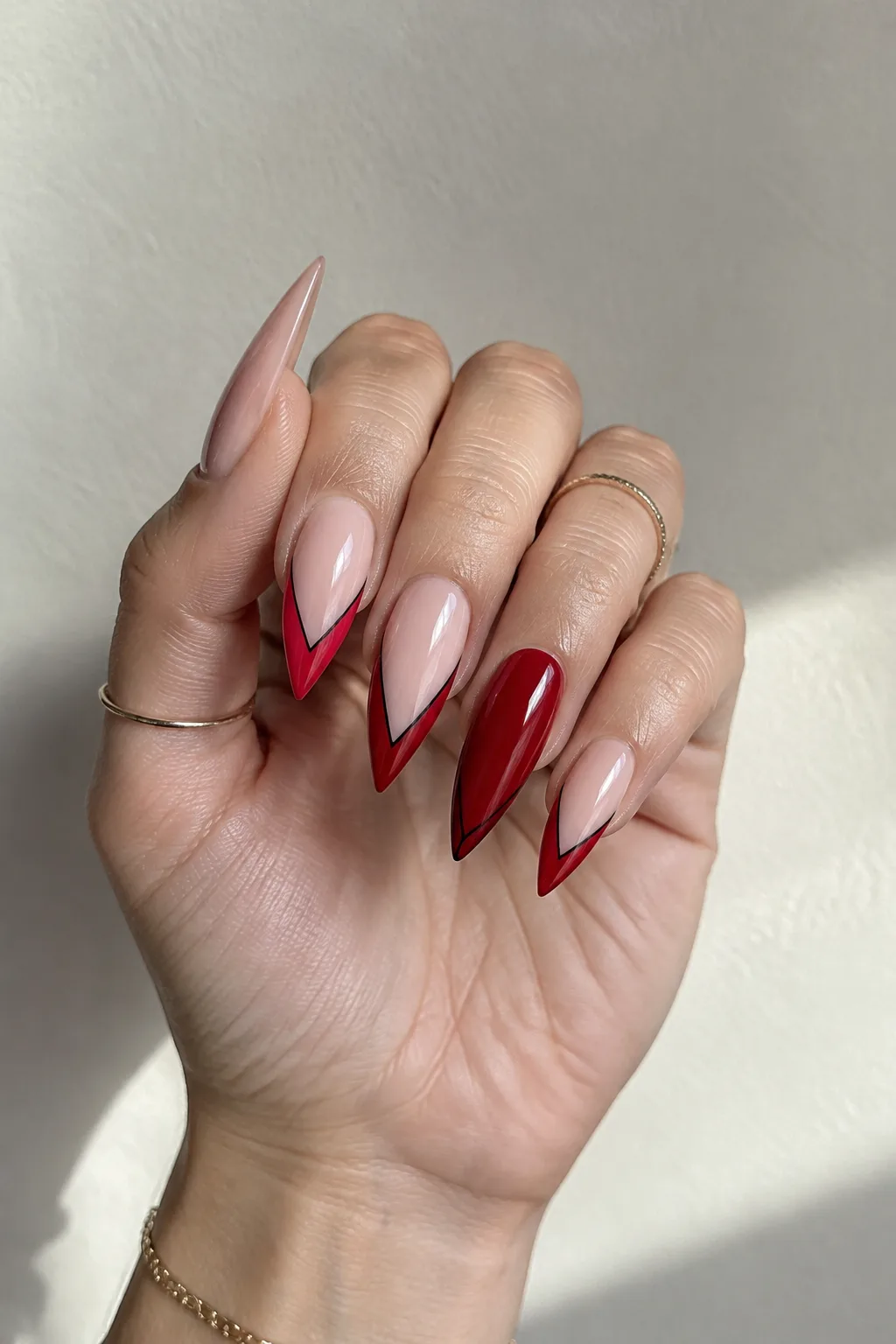 Scarlet V tips outlined in black on stiletto nails, nails to wear with a red dress