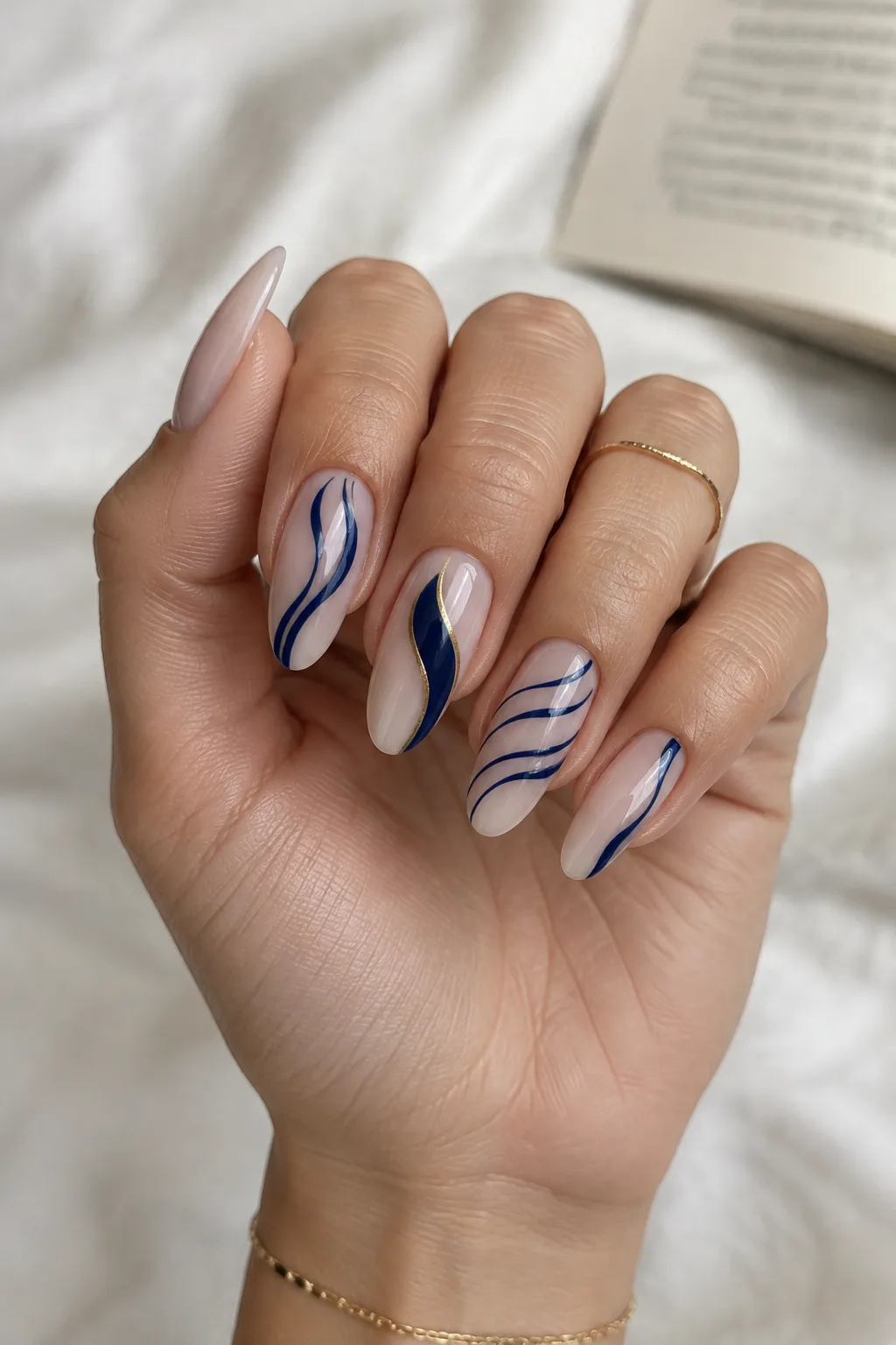 Negative space nails with navy swirls and a gold line for winter
