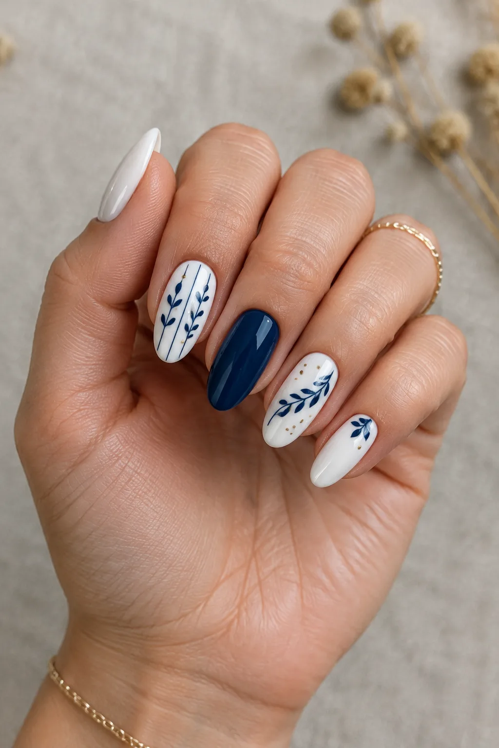 Milky nails with fine navy sprigs and gold dots, winter navy nail design
