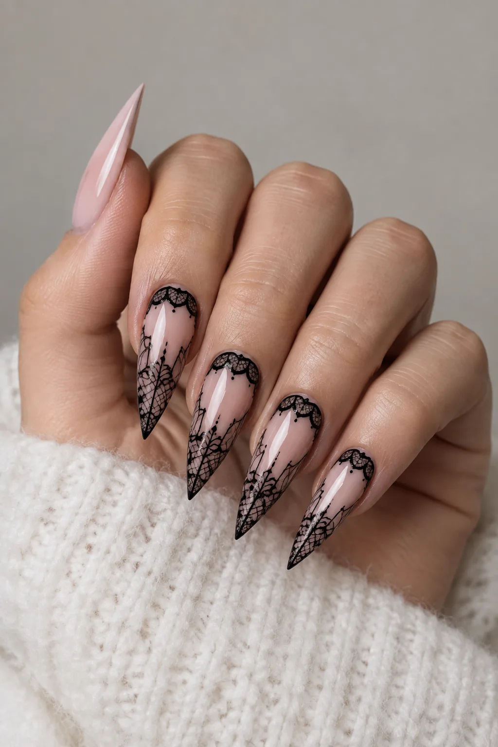 Black lace stiletto nail designs over a soft blush base