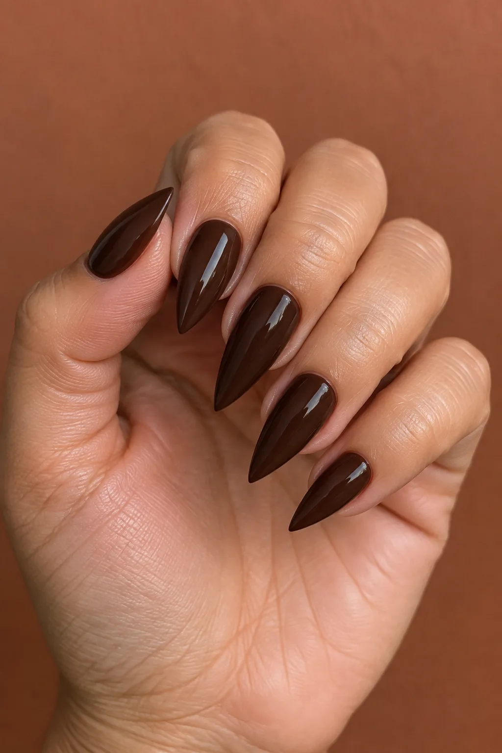 Short stiletto nail designs in espresso brown with a tapered point