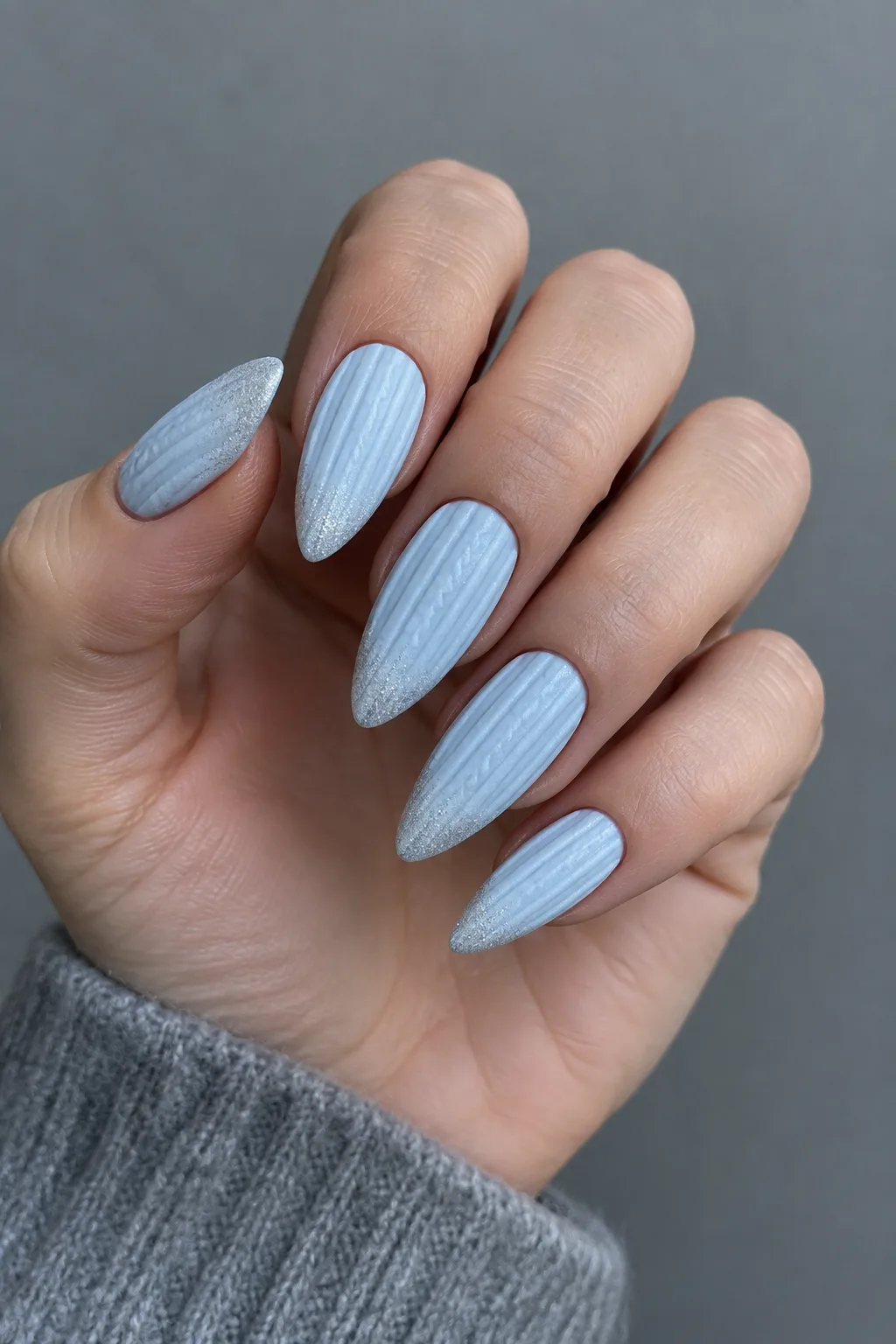Icy blue knit sweater nails with silver frost on long almond nails