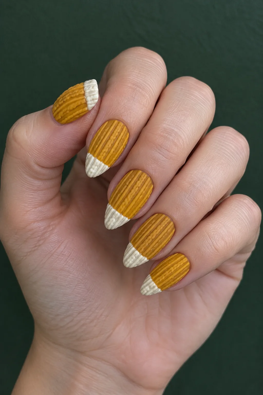 Mustard sweater nails with a cream knit cuff on arrowhead nails