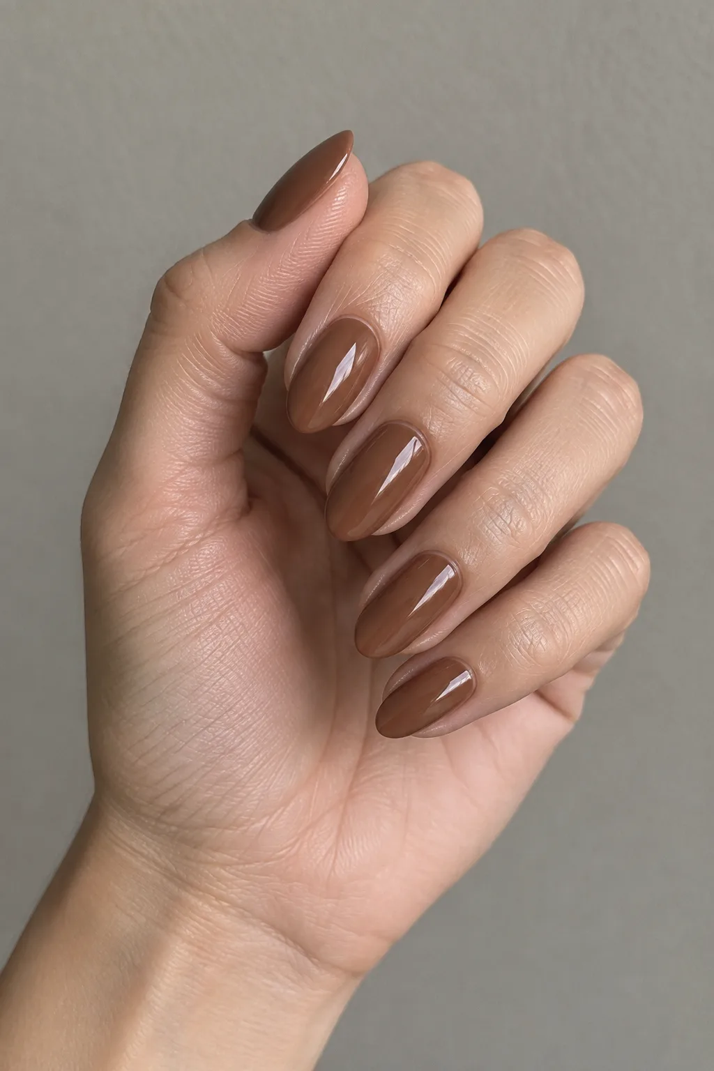 Warm pecan brown matte polish on short almond-shaped nails