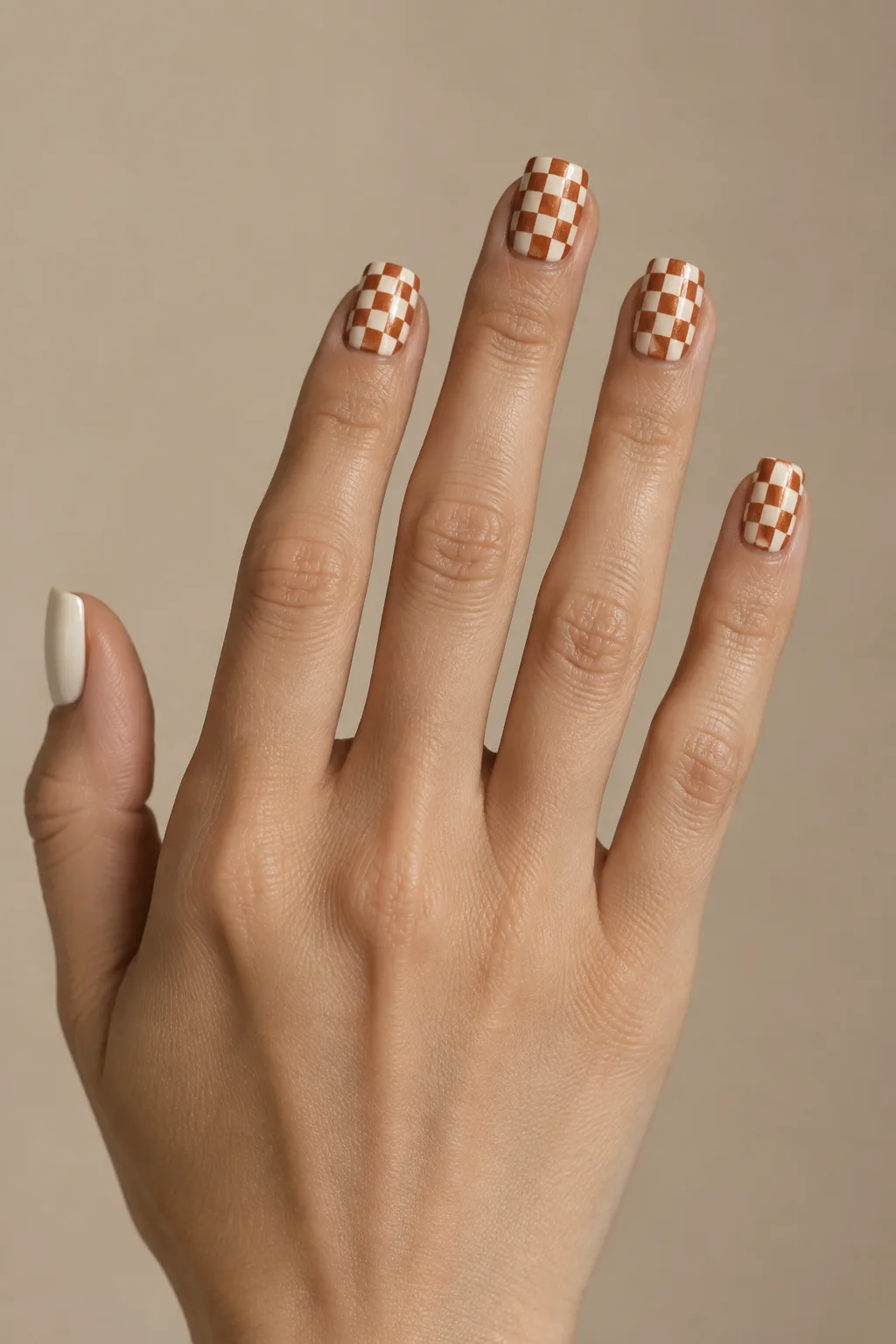 Copper and cream checkerboard pattern painted on short square nails