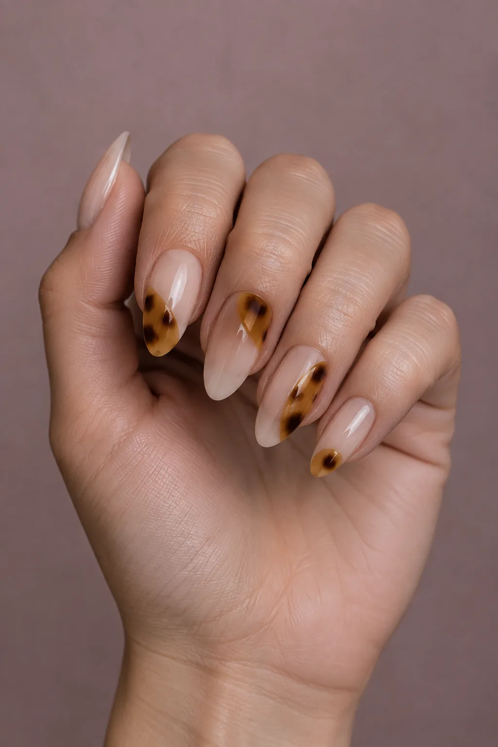 Negative space tortoiseshell nails with amber patches on clear long almond nails