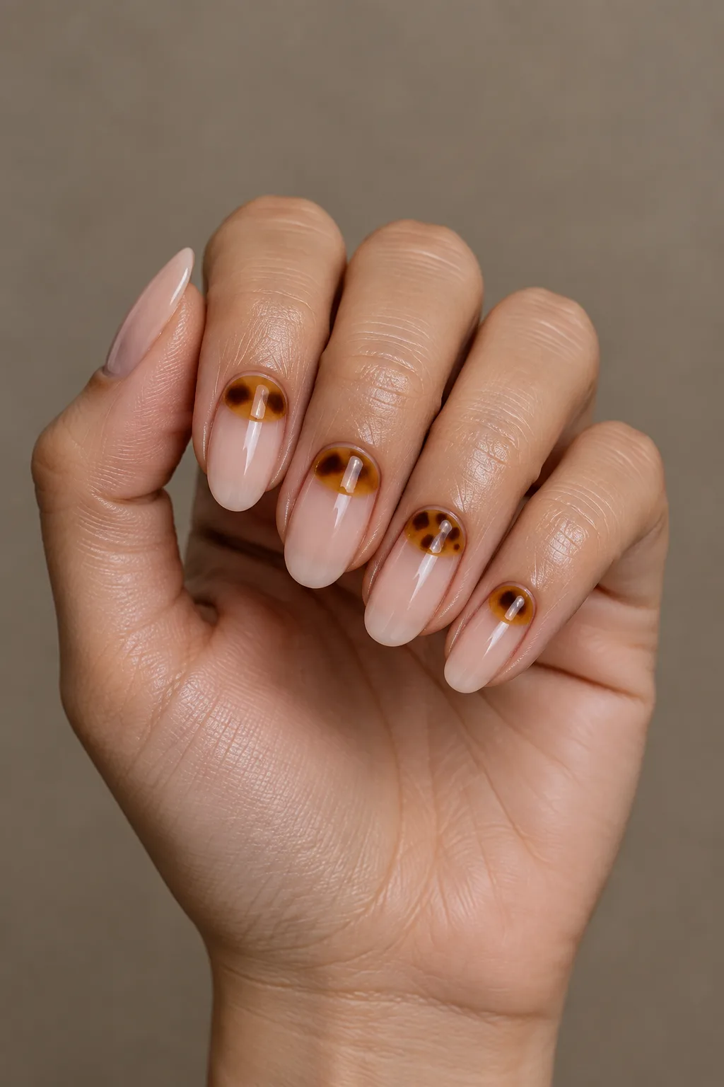 Tortoiseshell nails as amber half moons at the cuticle on oval nails