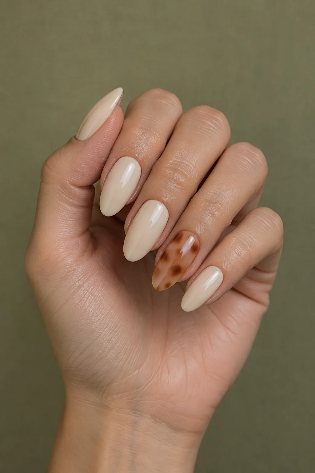 Nude long oval nails with one sheer tortoiseshell accent nail